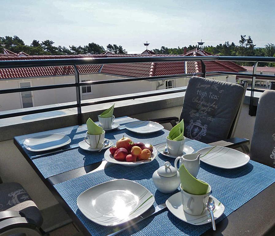 a table with plates of food on a balcony at Haus Meeresblick - Ferienwohnung Schwalbennest A 4.06 (Ref. 128721) in Baabe