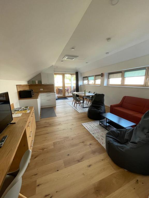 a living room with a red couch and a table at Das Haus am Anger in Breitenbrunn