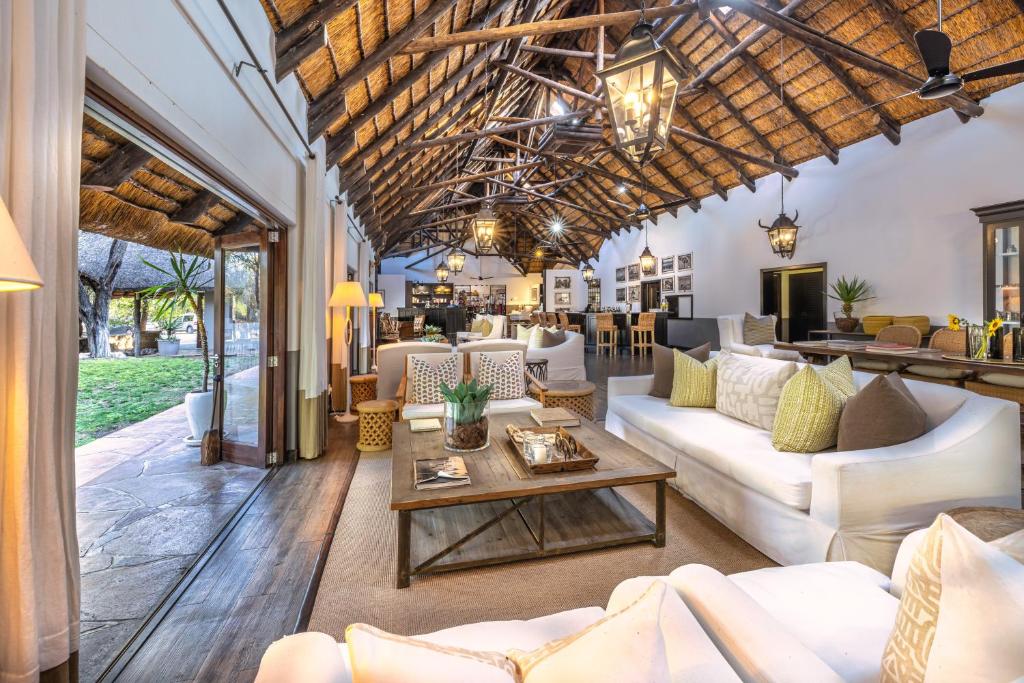 a living room with white couches and a table at Mushara Lodge in Namutoni