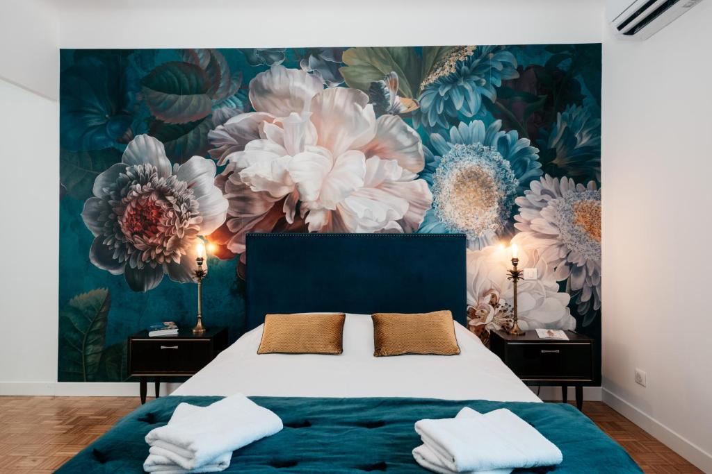 1 dormitorio con 1 cama con un mural floral en la pared en Les Précieuses Suites & Spa II, en Aviñón