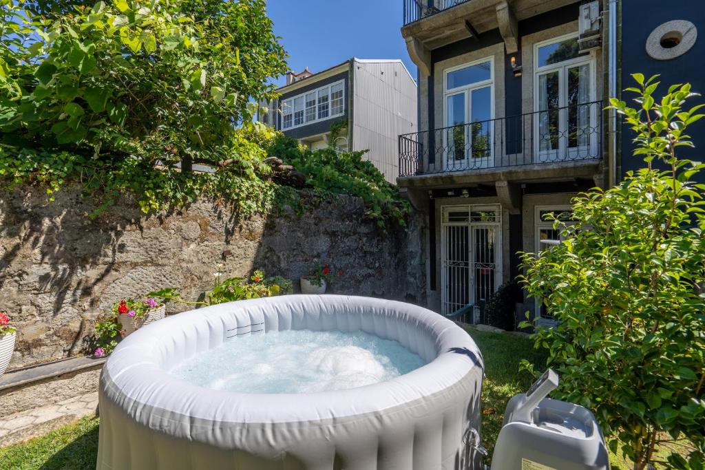 a hot tub in the yard of a house at Homely Noble Flats - Garden & Jacuzzi in Porto