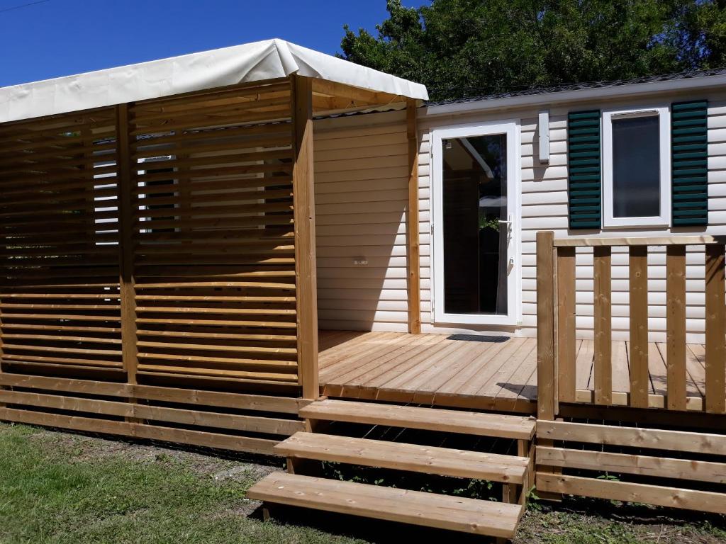 a wooden cabin with a deck with a porch at Mobilhome 6 pers avec Clim in Saint-Georges-de-Didonne