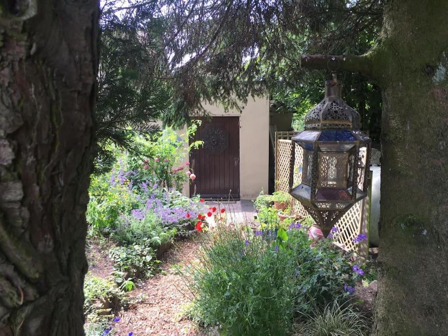 un jardín con una lámpara de araña frente a una casa en The Jewel in the Crown, countryside escape, en Rushton Spencer
