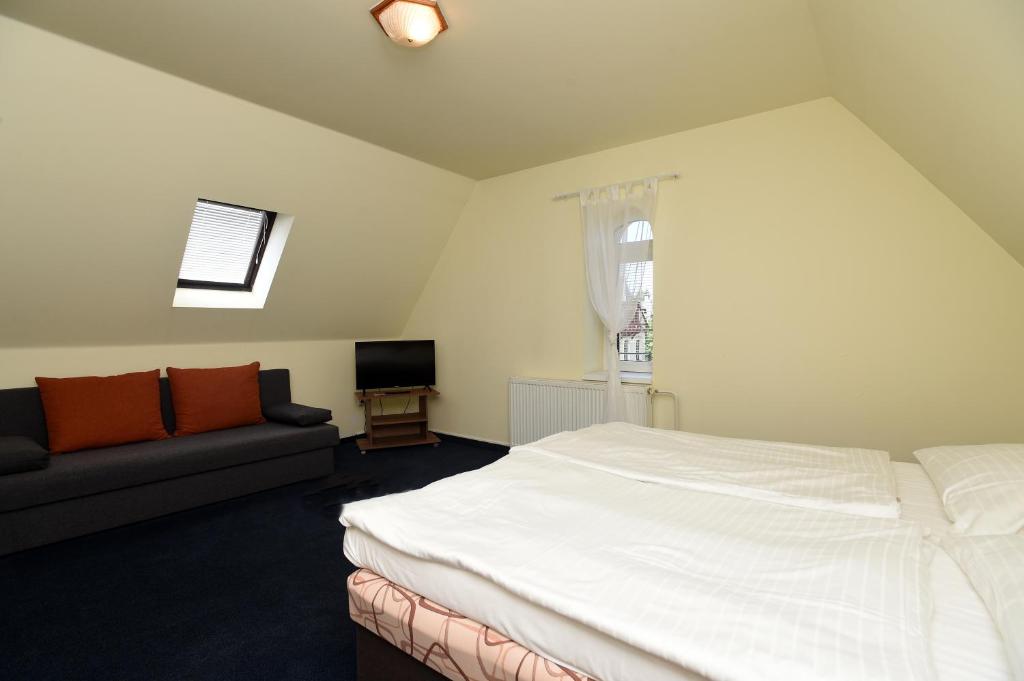 a bedroom with a large bed and a couch at Hotel U Jezírka in Liberec