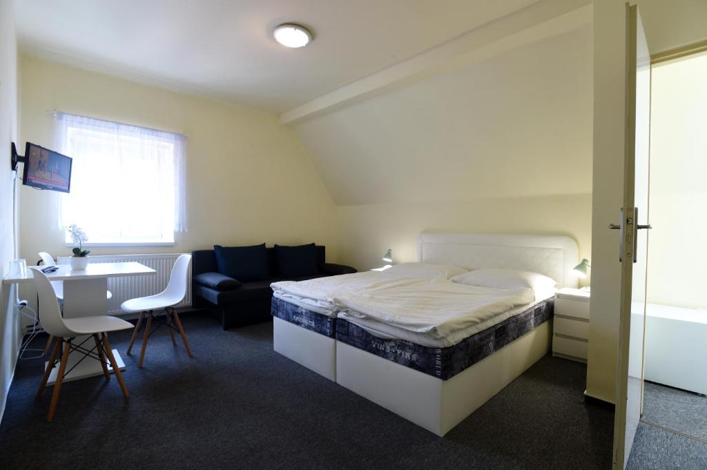 a bedroom with a bed and a table and a couch at Hotel U Jezírka in Liberec