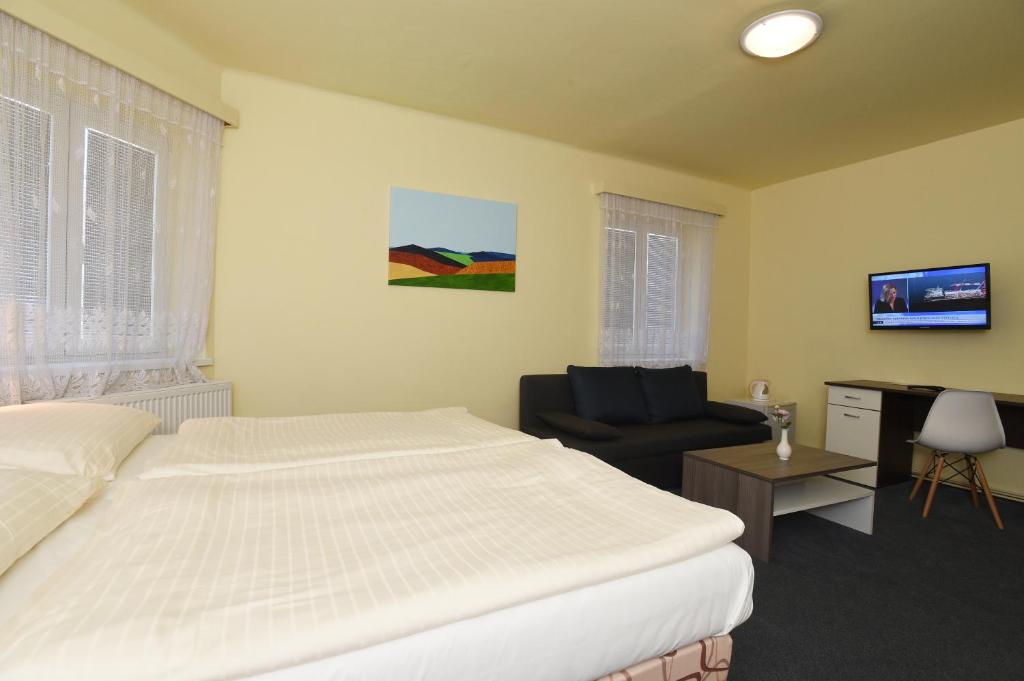 a hotel room with a bed and a chair at Hotel U Jezírka in Liberec
