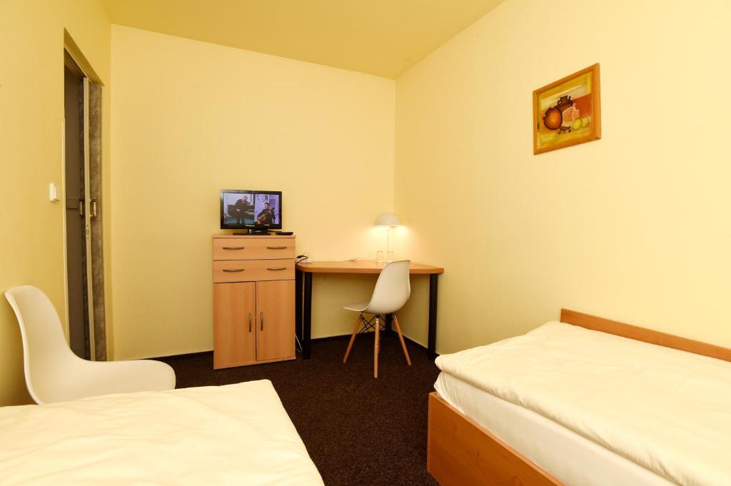 a hotel room with a bed and a desk with a computer at Hotel U Jezírka in Liberec