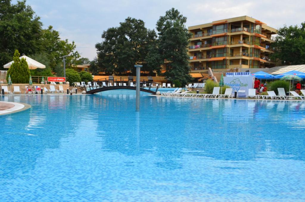 une grande piscine bleue avec un hôtel en arrière-plan dans l'établissement Les Magnolias Hotel, à Primorsko