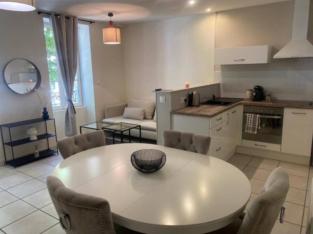 a kitchen and living room with a white table and chairs at Saint-Cosme Home in Chalon-sur-Saône