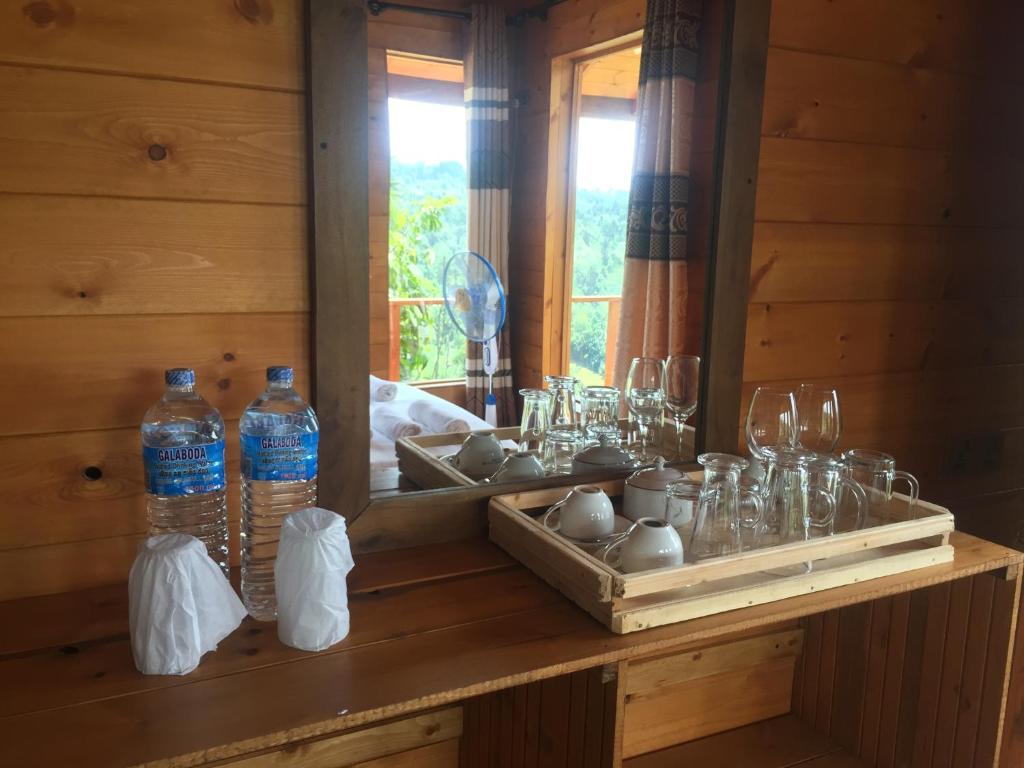 een houten tafel met glazen en flessen erop bij Green Nature Paradise Ella in Ella
