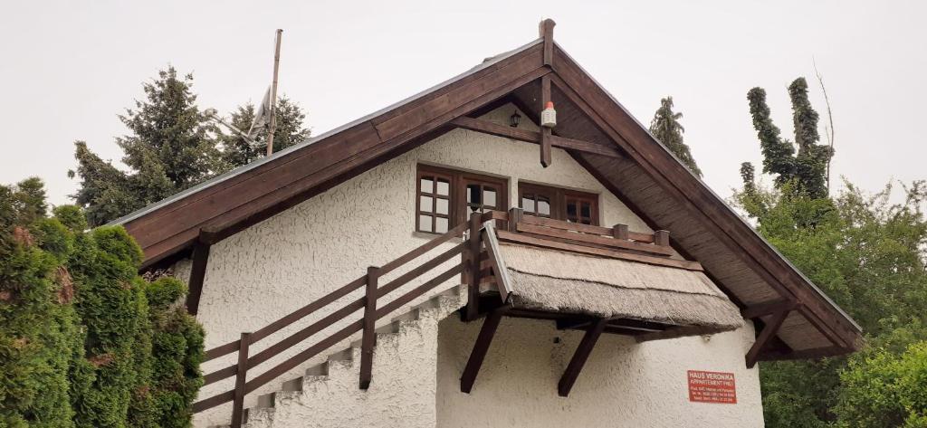 ein Haus mit einem Balkon an der Seite in der Unterkunft Haus Veronika in Zamárdi