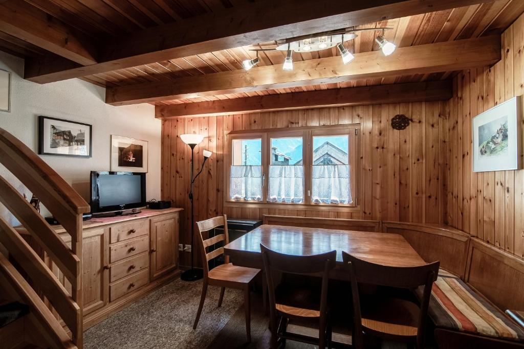 una sala da pranzo con tavolo e TV di Baita dal Gat by Quokka 360 - modern wooden chalet in Faido a Sobrio