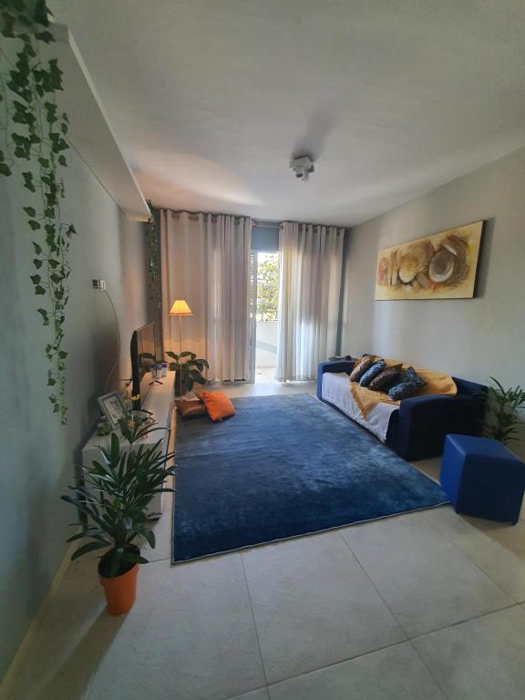 sala de estar con sofá y alfombra azul en Jequiti-Mar Apto aconchegante na Enseada, en Guarujá