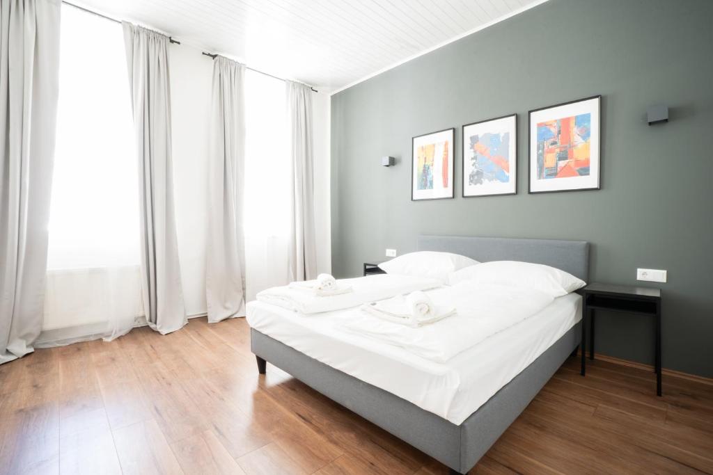 um quarto com uma cama grande e lençóis brancos em Lovely 2-bedroom apartment next to Praterstern em Viena