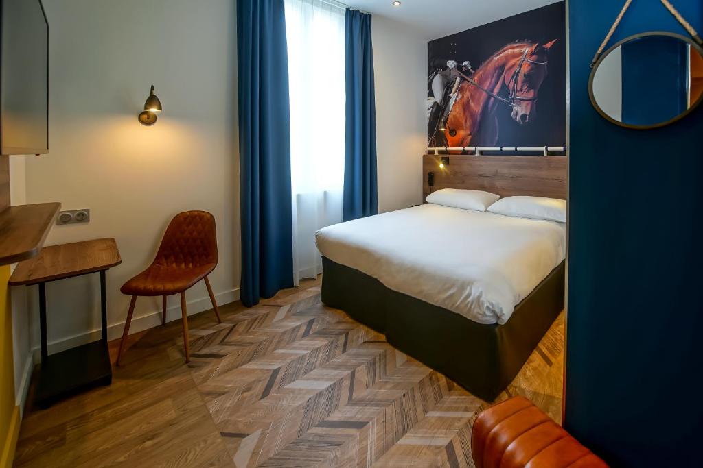 a bedroom with a bed and a table and a chair at ibis Styles Saumur Gare Centre in Saumur