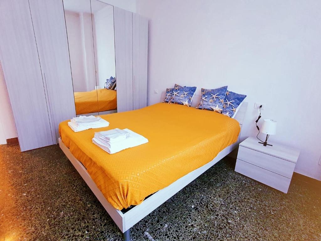 a bedroom with a bed with yellow sheets and a mirror at Ariel in La Spezia