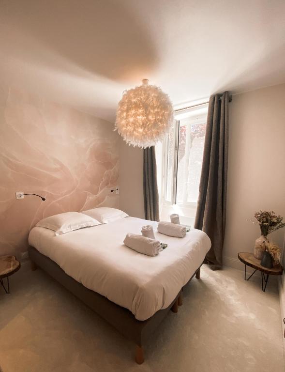 a bedroom with a large bed with a chandelier at Hôtel Restaurant "La Petite Auberge" in Bourg-Saint-Maurice