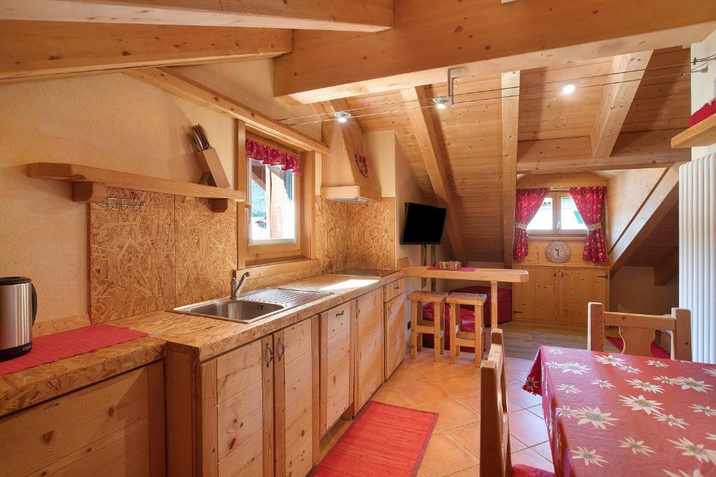 a kitchen with wooden cabinets and a sink in a cabin at La Baitina app C in Livigno