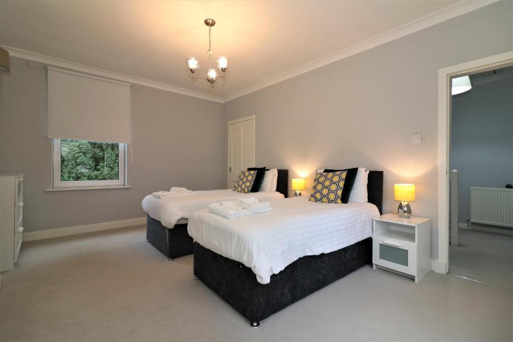 a bedroom with two beds and a window at Signature - Moss View in Govan