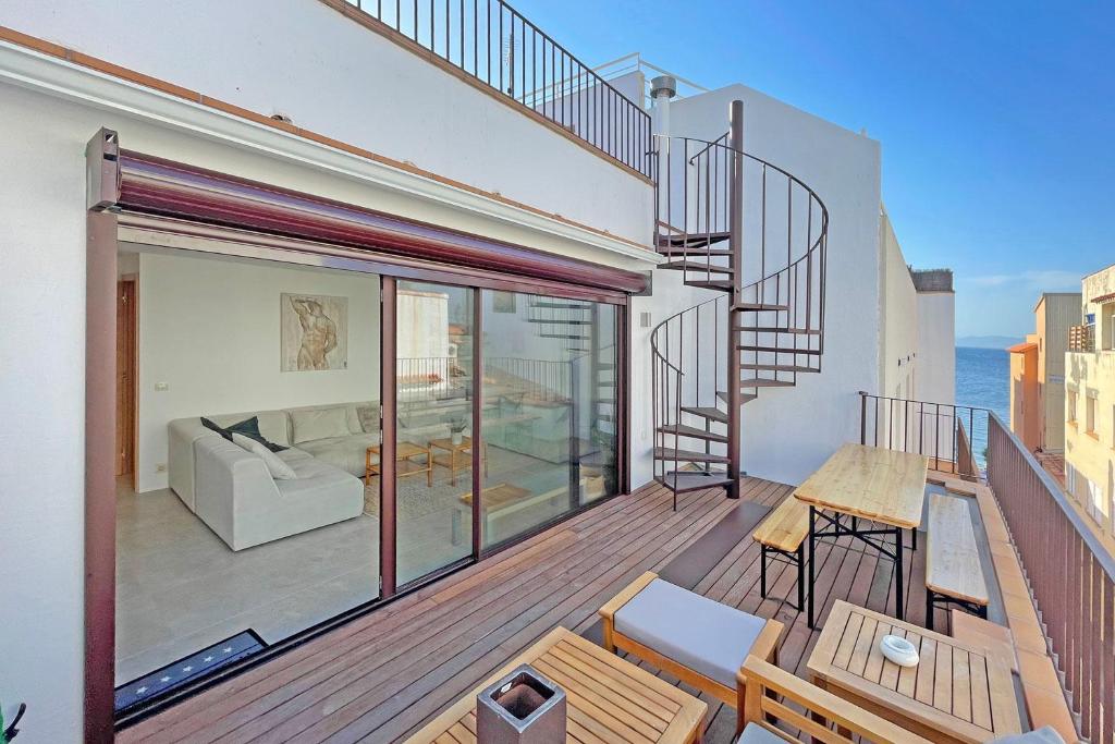 einen Balkon mit einem Wohnzimmer und einer Treppe in der Unterkunft Luxe 8P dorpshuis centrum l'Escala 50m van strand in L'Escala
