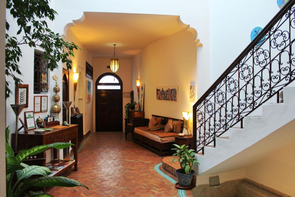 a living room with a staircase and a couch at Dar Manara - Medina d'Asilah in Asilah