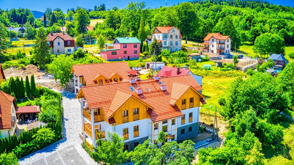 widok z powietrza na dom z pomarańczowym dachem w obiekcie Aparthotel Przy Starej Piekarni VIP by ROYAL APARTS w Szklarskiej Porębie