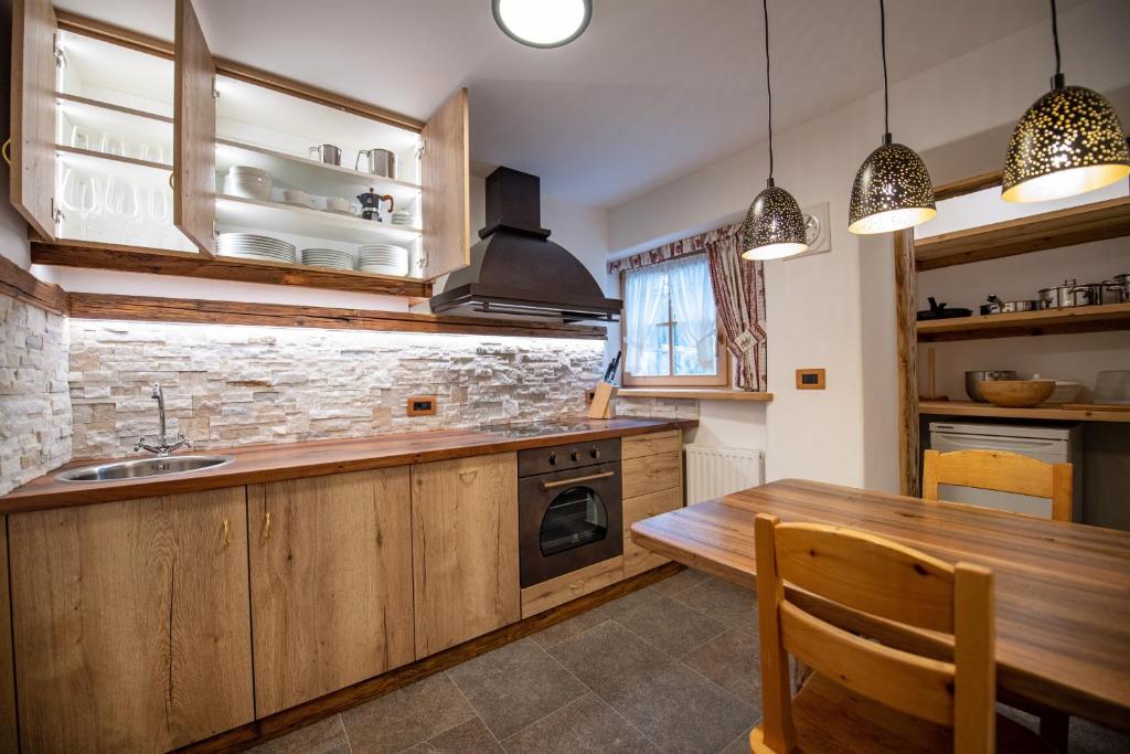a kitchen with wooden cabinets and a wooden table at Apartments Berna in Ortisei