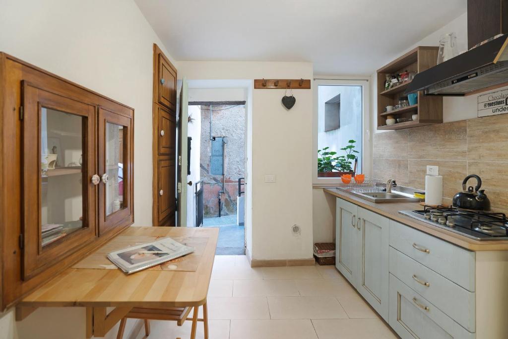 cocina con mesa de madera y fregadero en Hemingway's Shelter, en La Spezia