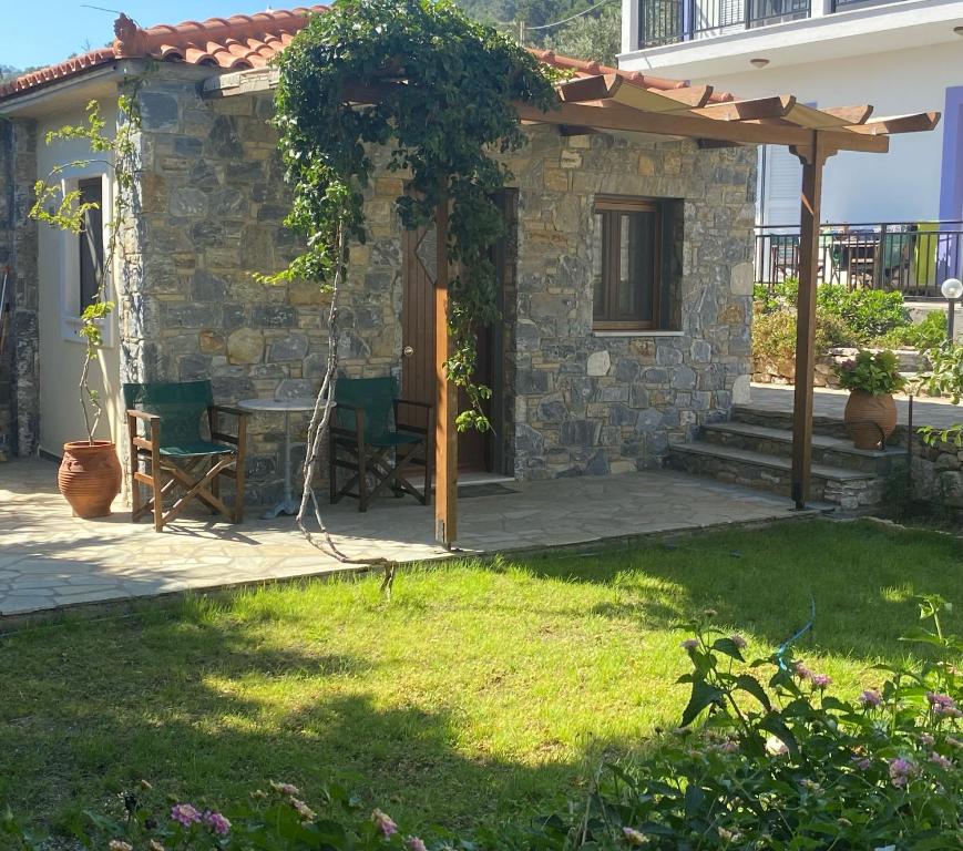 un patio con tavolo e sedie di fronte a una casa di Christina ad Ágios Konstantínos