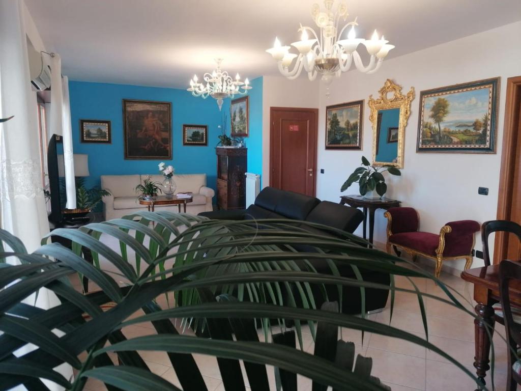 uma sala de estar com paredes azuis e um lustre em B&BYanet's Beautiful House em Civitavecchia