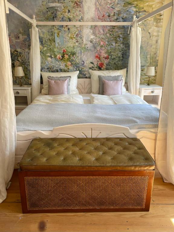 a bedroom with a canopy bed with a tufted bed sidx sidx at REFUGIUM Theresienstraße 19 - Chambre Morisot in Rhodt unter Rietburg