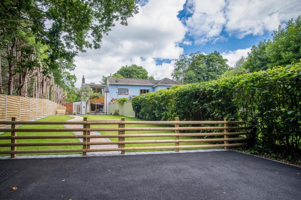 a wooden fence in front of a house at Wern Y Glais - 2 Bedroom Cottage - Glais in Swansea