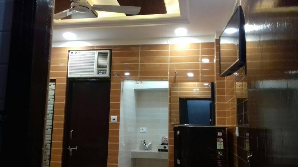 a bathroom with a black refrigerator and a mirror at Posh, Nice Foreigner Area Lajpat Ngar Luxury Room in New Delhi