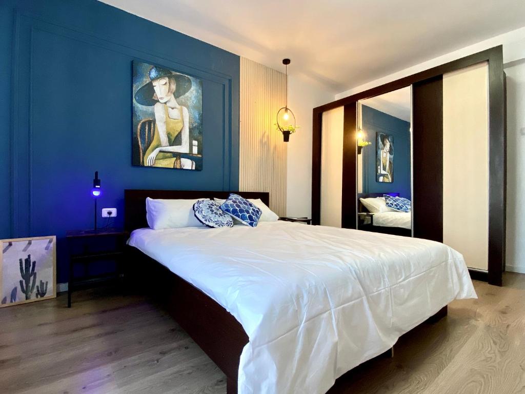 a bedroom with a large bed with a blue wall at Apart.Boutique B. Mangalia in Mangalia
