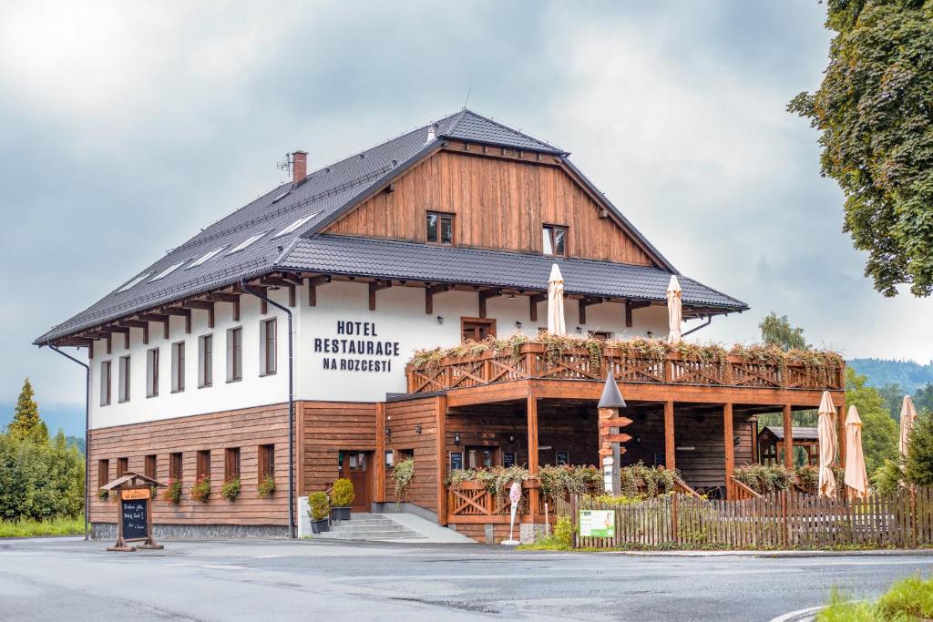 a large wooden building with a sign on it at Hotel Na Rozcestí in Čeladná