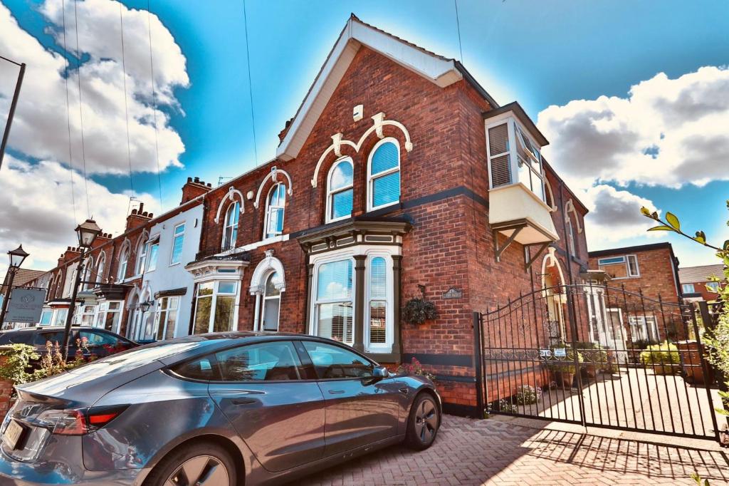 a car parked in front of a brick house at The Bays Clee Rd in Cleethorpes