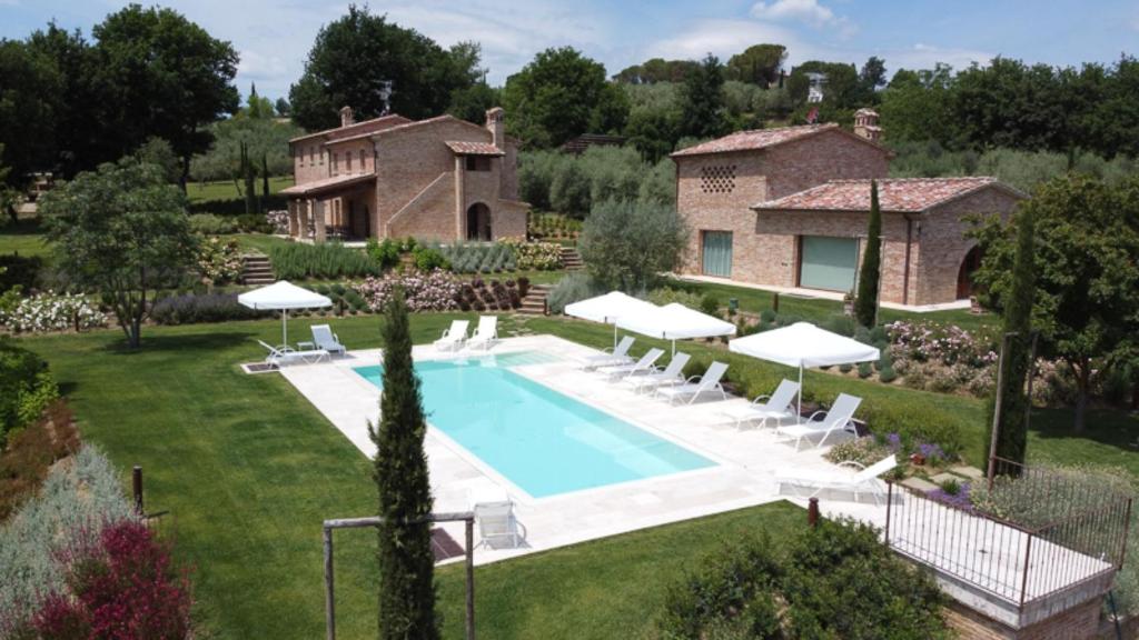 a villa with a swimming pool in front of a house at Villa Exclusive Fonte Ripa in Foiano della Chiana