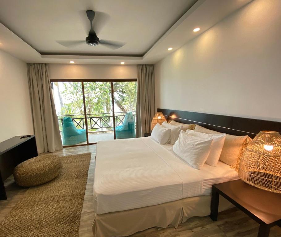 a bedroom with a large bed and a large window at Canopus Retreat Thulusdhoo in Thulusdhoo