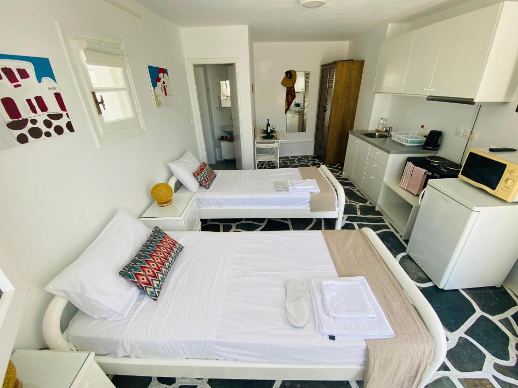 Habitación pequeña con 2 camas y cocina en Sing and Blossom Accommodation, en Mykonos ciudad