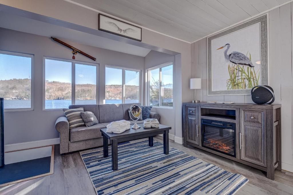 a living room with a couch and a fireplace at Modern Winnipesaukee Lake Front Retreat Siena in Alton