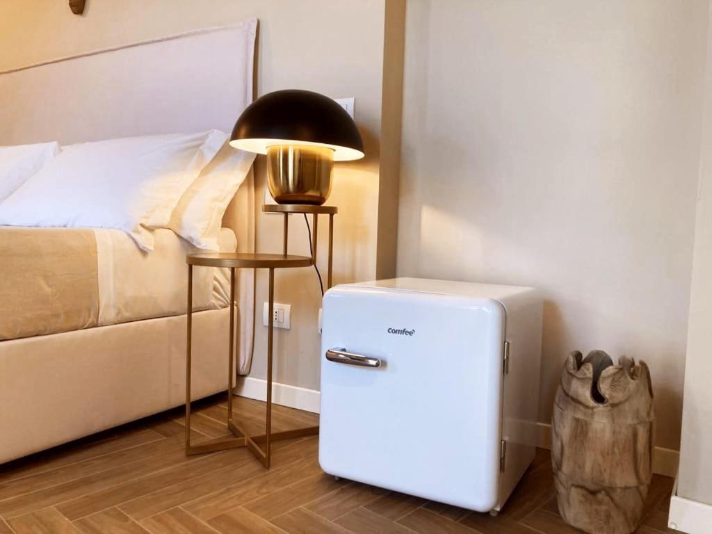a small refrigerator in a room next to a bed at Gatto Bianco Rooms 42 in Bergamo