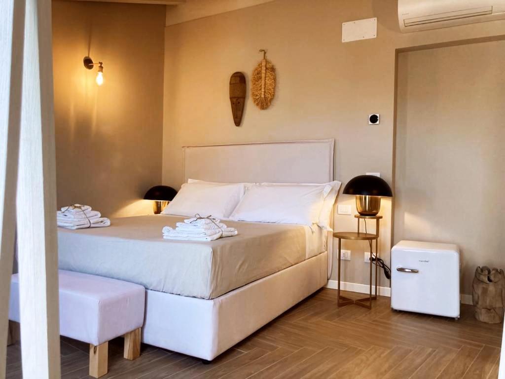 a bedroom with a white bed with two towels on it at Gatto Bianco Rooms 42 in Bergamo