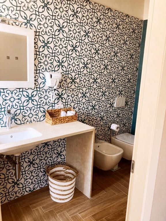 a bathroom with a sink and a toilet at Gatto Bianco Rooms 42 in Bergamo
