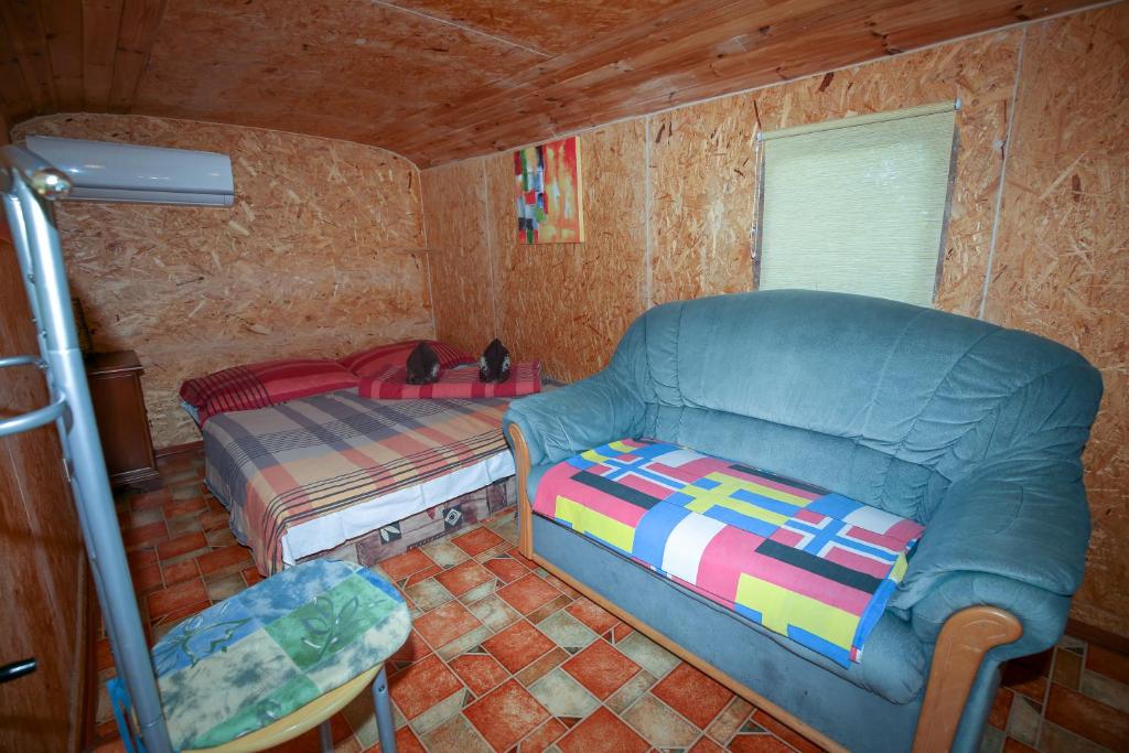 uma sala de estar com um sofá e uma cama em Karavan Sturovo em Štúrovo