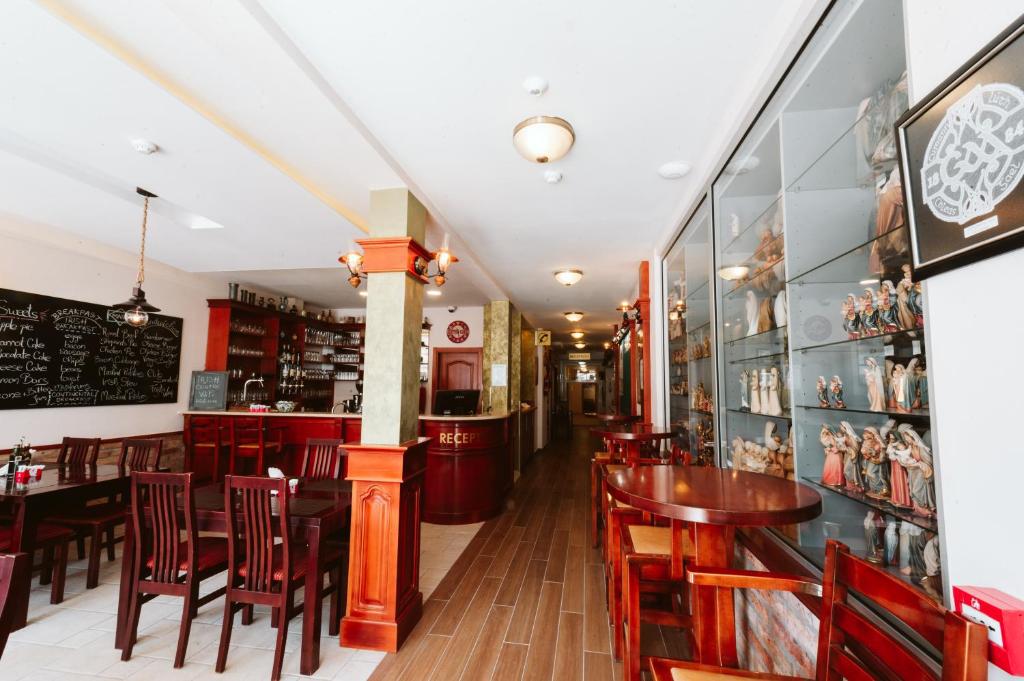 a restaurant with wooden tables and chairs and a bar at Hotel Medjugorje Irish Centre in Međugorje