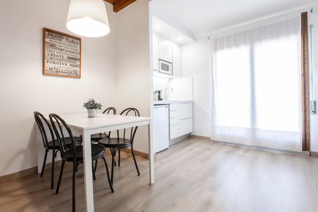 eine Küche und ein Esszimmer mit einem Tisch und Stühlen in der Unterkunft Outdoor Apartaments - Spot in Andorra la Vella