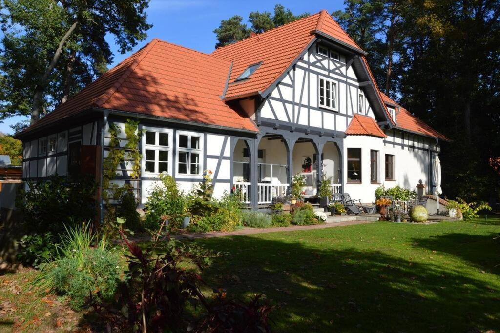 una casa blanca con techo naranja en Ferienwohnung im Landhaus Labes (Stechlinsee) en Neuglobsow