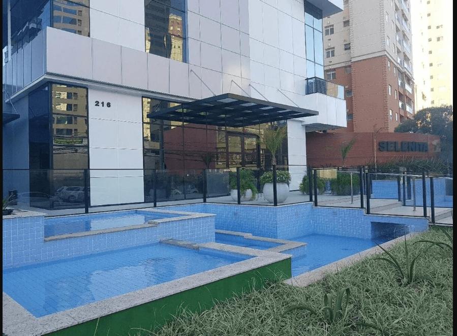 a building with a swimming pool in front of it at Conjunto Estudio e Duplex Selenita in Barueri