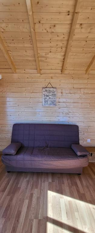 a purple couch in a room with a wooden ceiling at Las casitas de Pao in El Pinar del Hierro