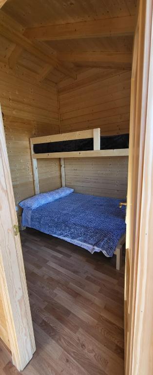 a room with a bed in a wooden cabin at Las casitas de Pao in El Pinar del Hierro